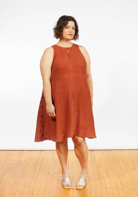 Front view of Austin Dress in rust linen, sleeveless A-line style with side buttons and keyhole neckline, worn by model.