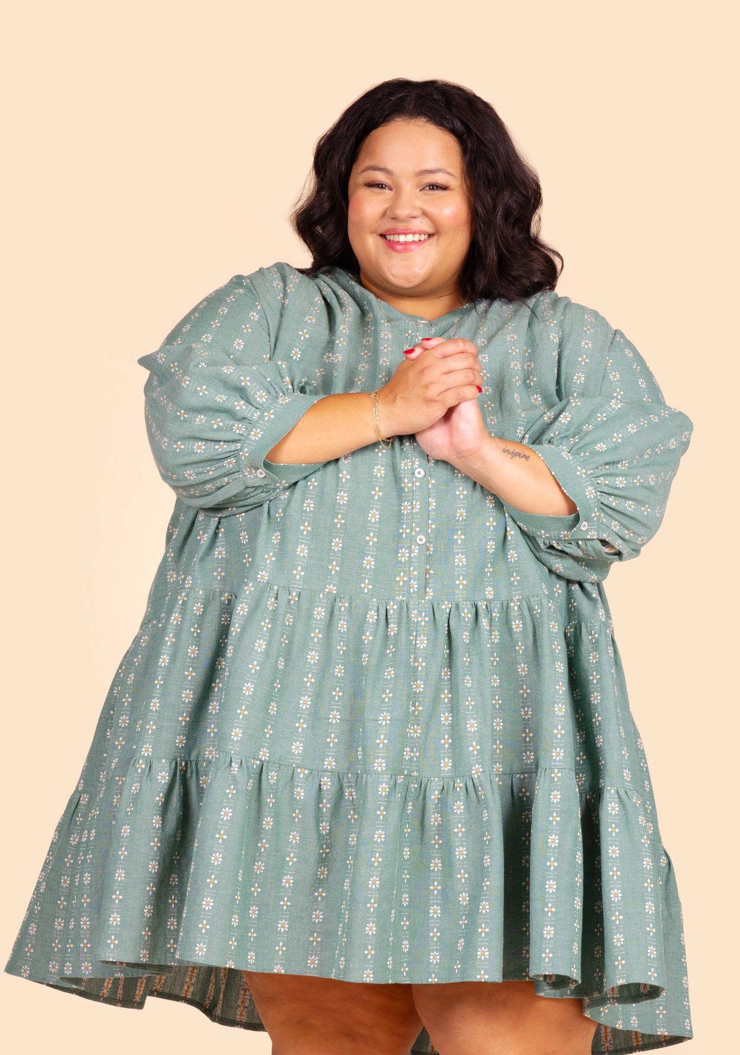 Front close-up of short Poppy Dress View C with long sleeves and floral print on green fabric.