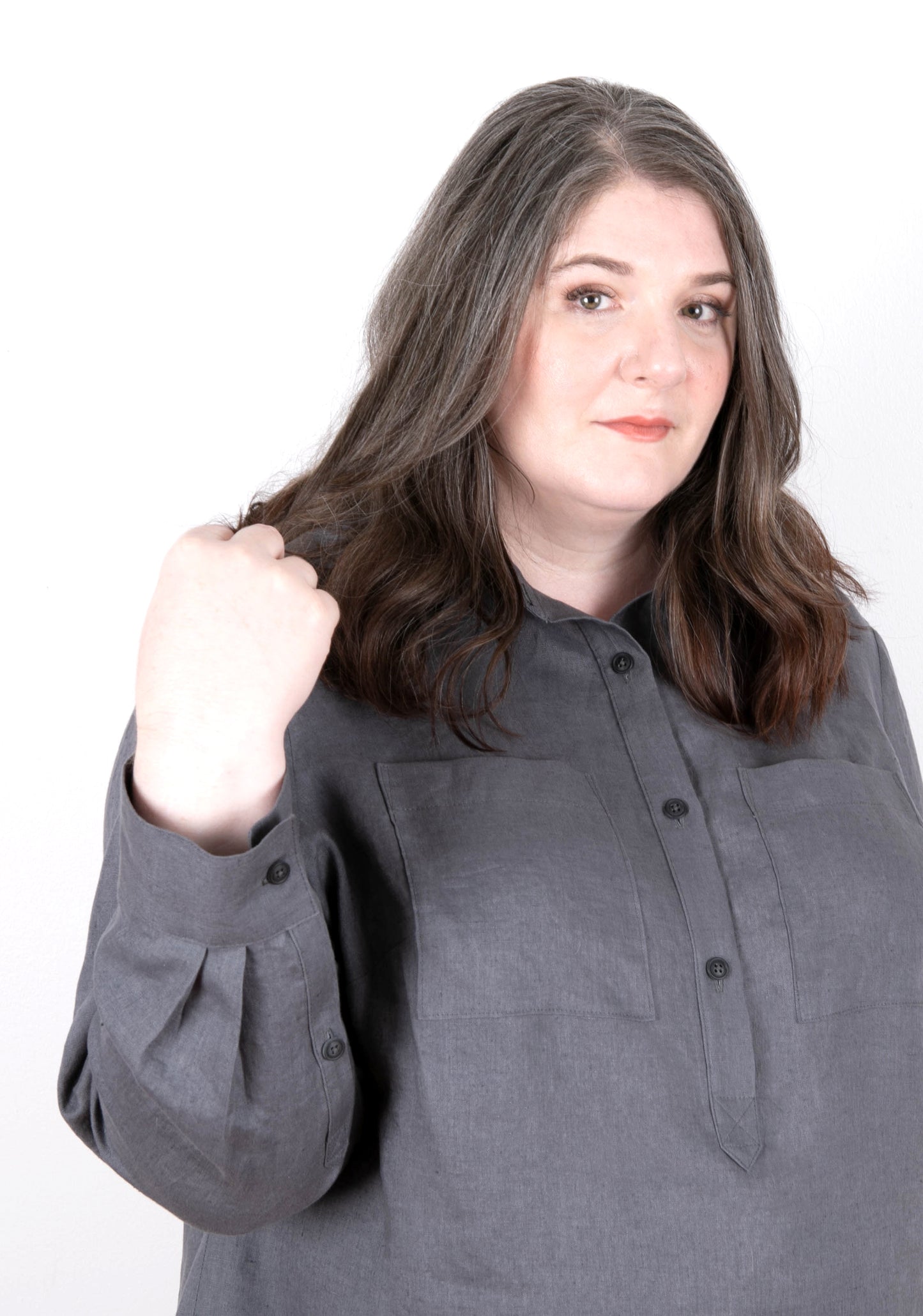 Close-up of Archer Popover shirt showing front placket, pockets, and pleated sleeve cuff.