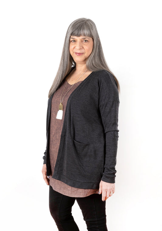 Three-quarter front view of charcoal Driftless Cardigan worn over Uniform Tunic.
