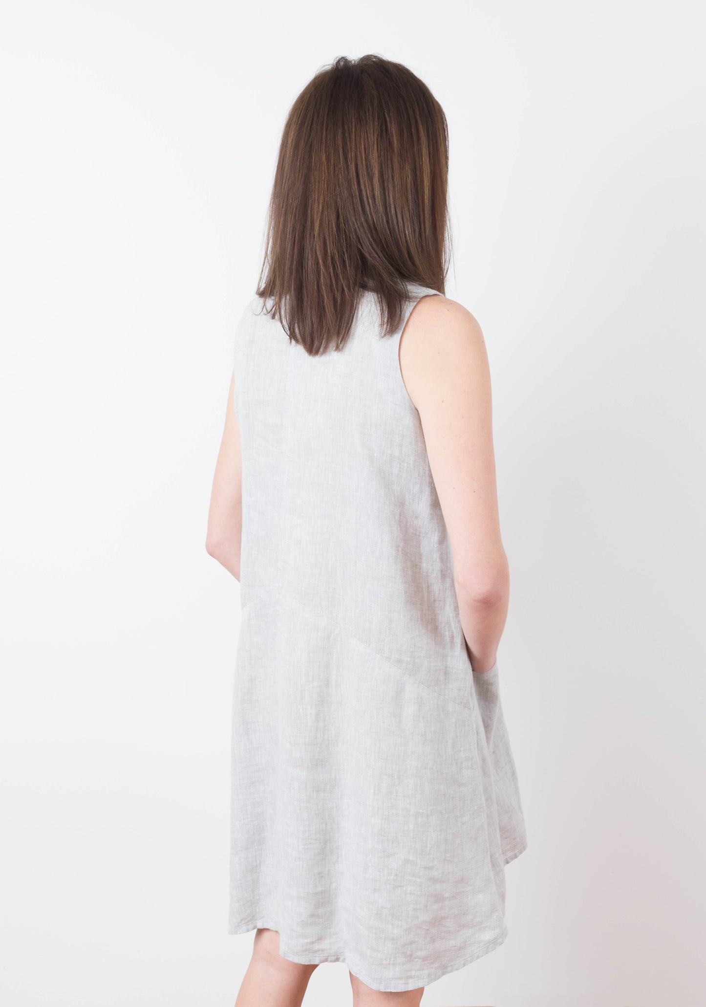 Back view of model wearing sleeveless Farrow Dress in solid grey linen, view A.