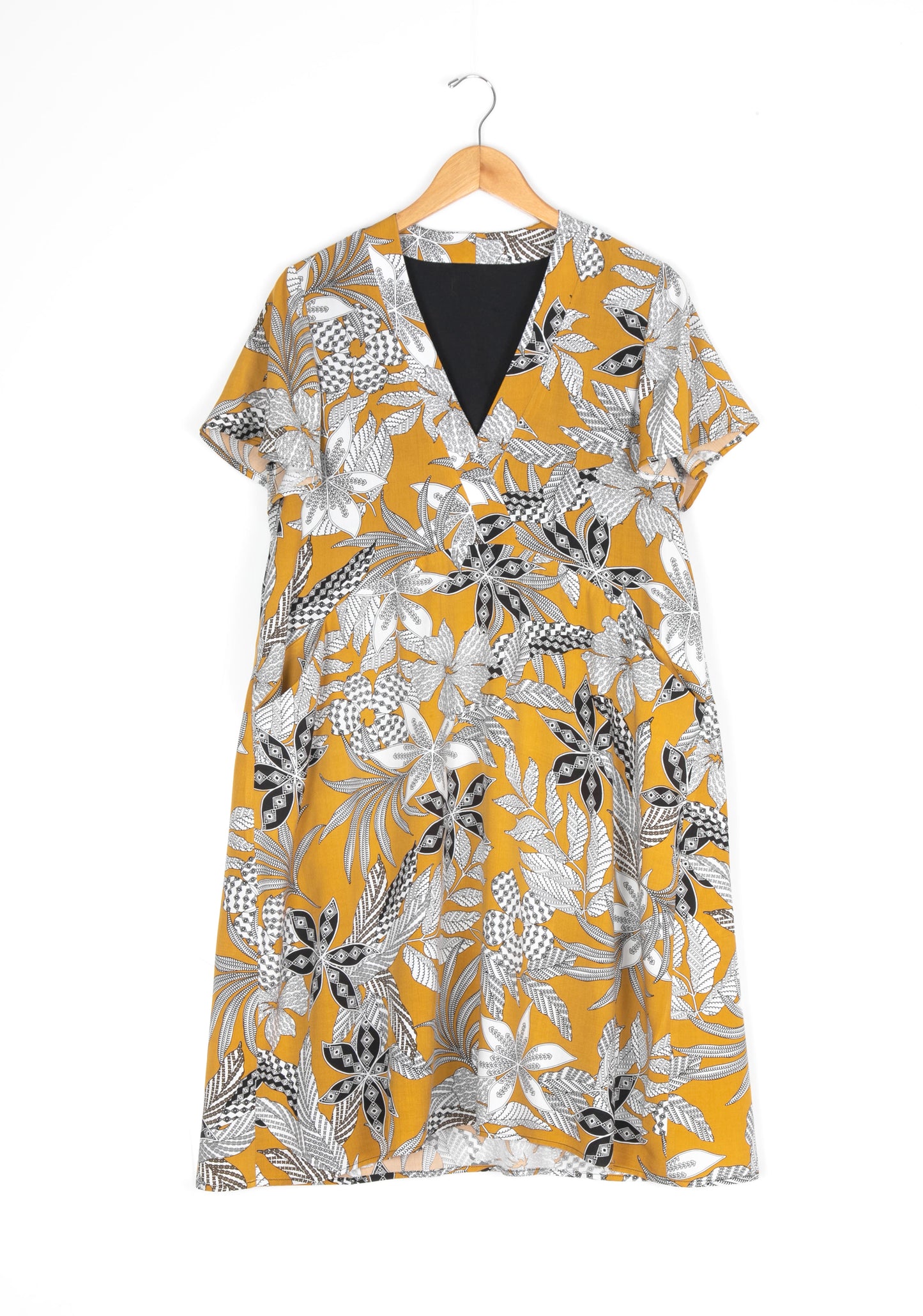 Flatlay of Felix Dress in yellow floral fabric, flutter sleeves visible.