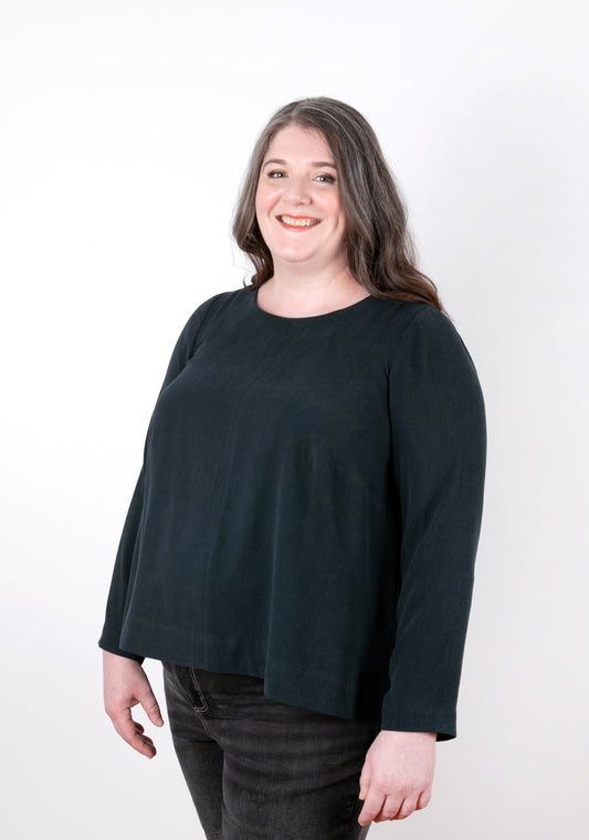 Model wearing dark long-sleeve Hadley Top, front view. Garment features a swing shape and jewel neckline.