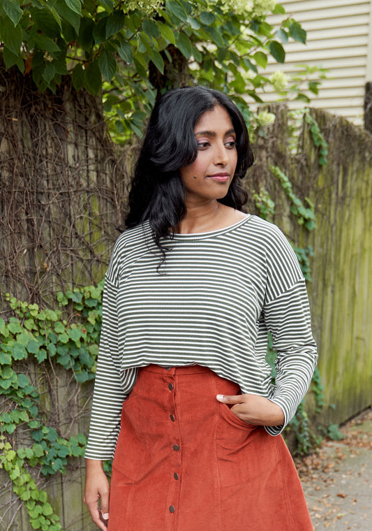 Model: Size 8, 5'5" | Model outdoors in long sleeve olive and cream striped Hemlock Tee with rust skirt.