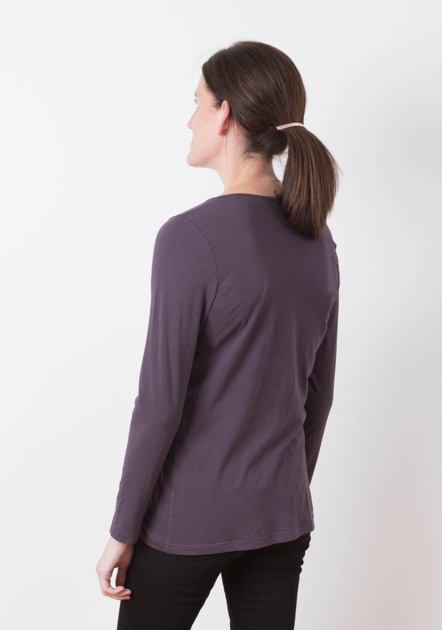 Model wearing Lark Tee with long sleeves and scoop neckline, back view.