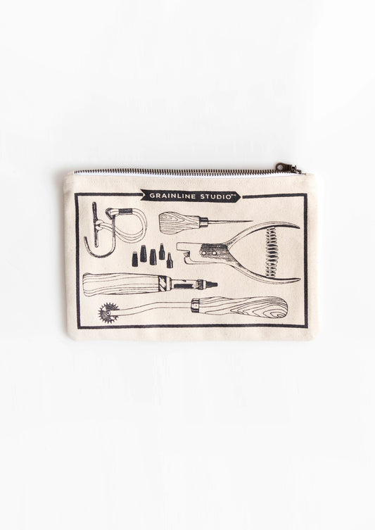 Flatlay of Grainline Studio Pattern Tools pouch on white background showing printed tool illustrations.
