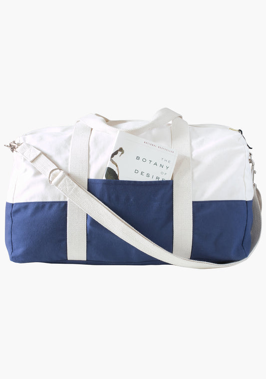 Portside Travel Set duffle bag in blue and natural canvas with book in exterior pocket.