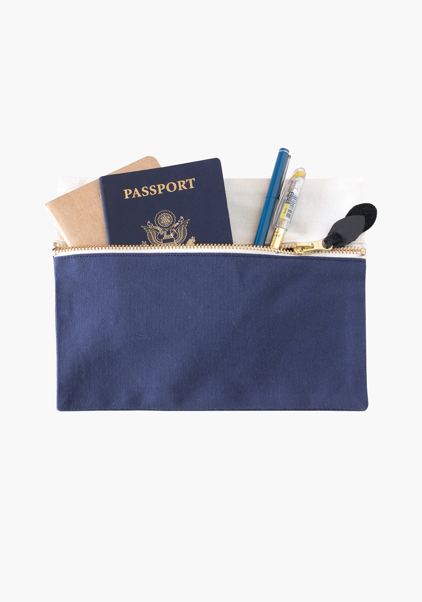 Portside zip pouch filled with passport, pens, and notebooks in blue and natural canvas.