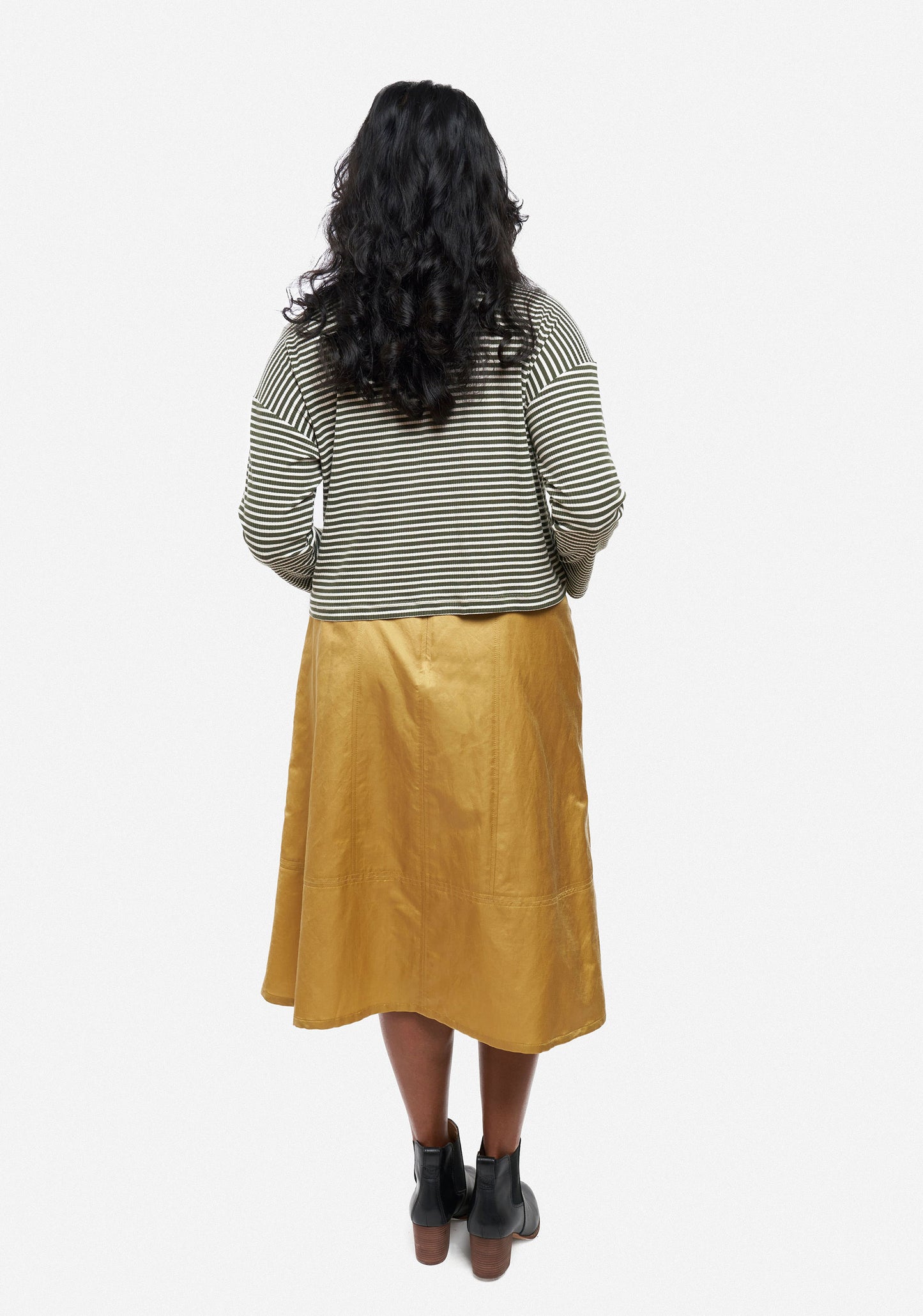 Back view of Reed Skirt in golden rayon showing midi length, flare, and seaming details.