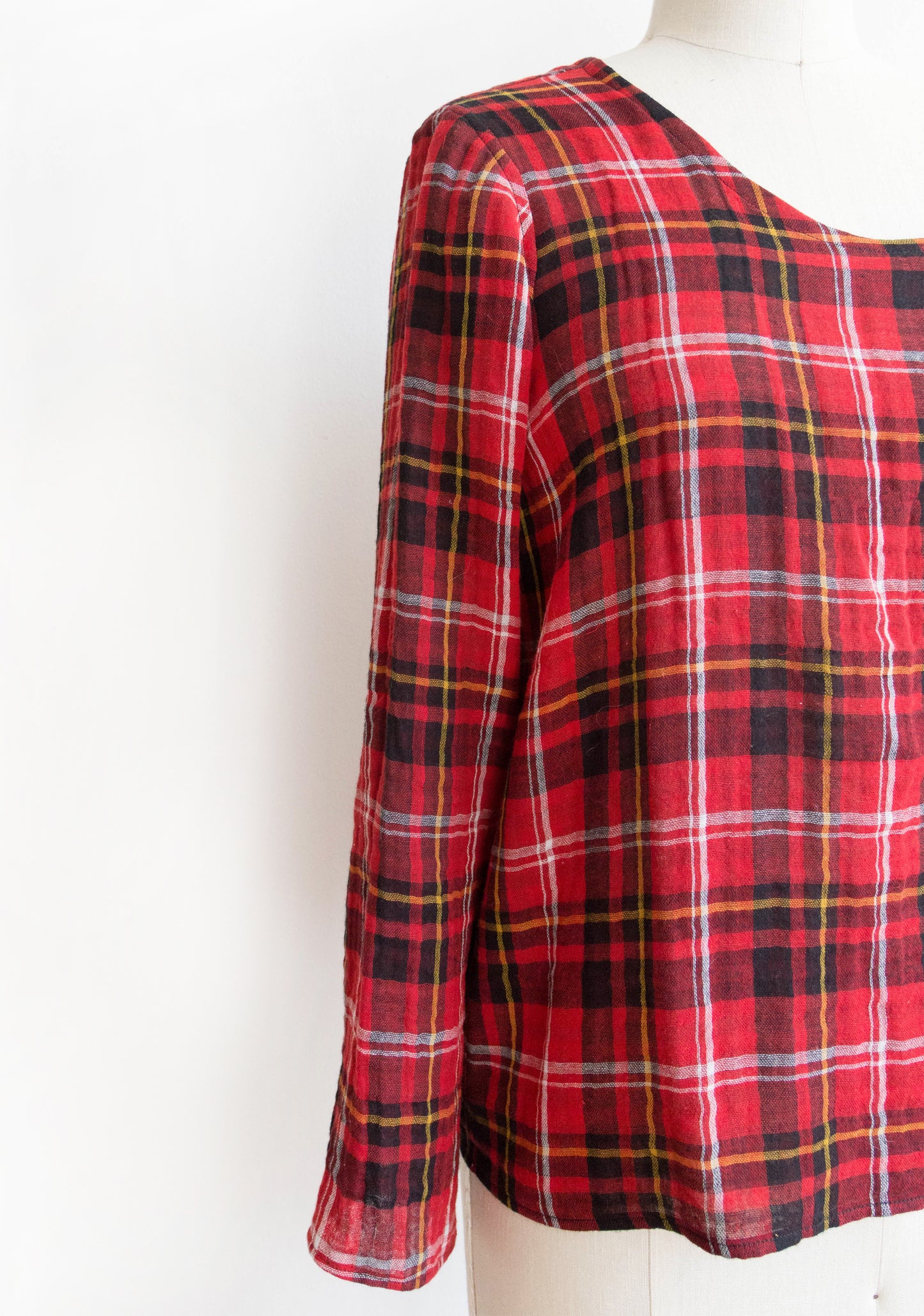 Close-up of Scout Tee long sleeve add-on in red plaid on dress form.