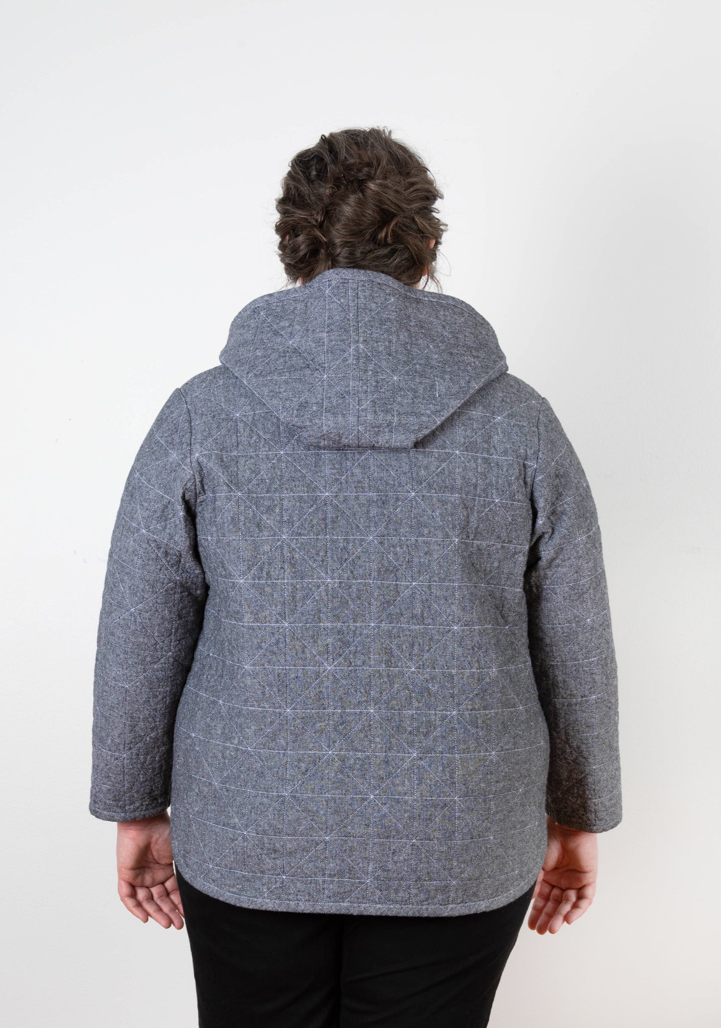 Back view of gray Tamarack Jacket with hood add-on folded down, geometric quilting visible.