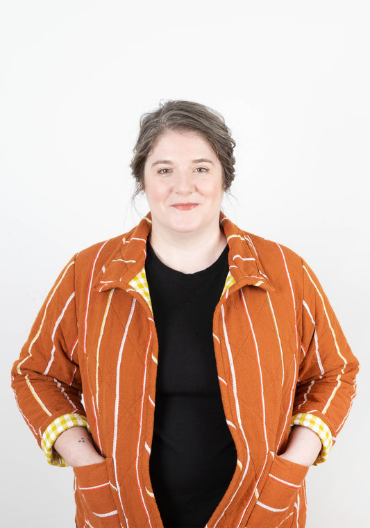 Front view of model wearing Tamarack Jacket with collar add-on and orange striped fabric, size 0-32.