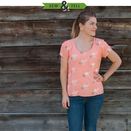 Sew & Tell: Scout Tee in coral camel print fabric with short sleeves, worn with jeans against a weathered wood wall