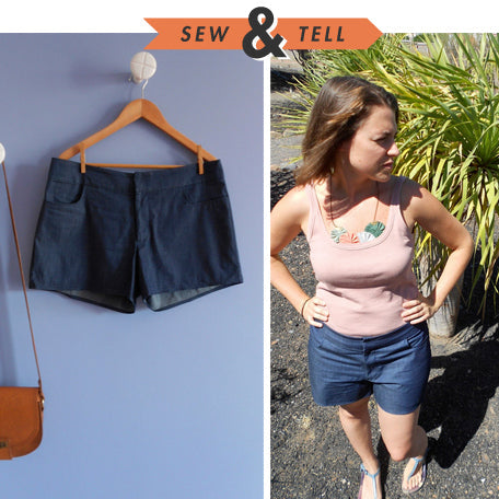 Sew & Tell: Maritime Shorts in dark denim on a wooden hanger and styled with a pink tank top and leaf necklace outdoors