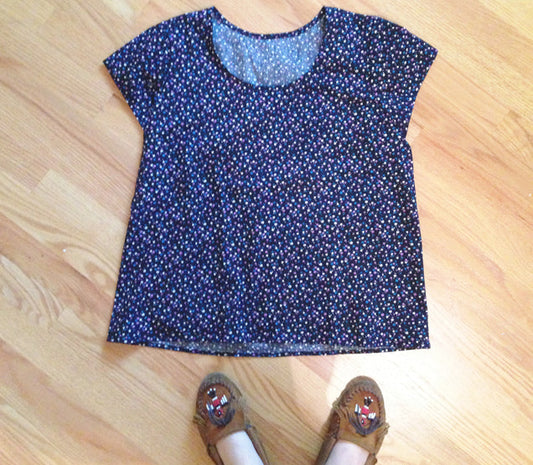 Scout Tee in navy small floral cotton laid flat on wood floor next to brown embroidered moccasins with fringe detail