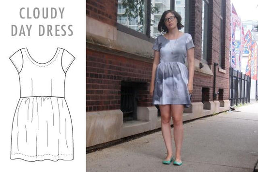 Cloudy Day Dress: line drawing and model wearing lavender chambray short-sleeve gathered dress against a brick building