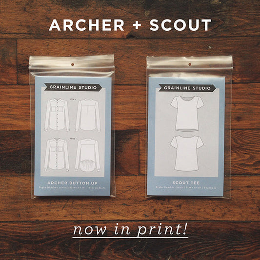 Archer Button Up and Scout Tee pattern envelopes on wood surface with now in print text overlay
