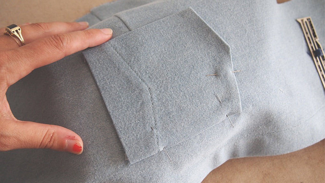 Hand positioning pinned breast pocket over bust dart on denim Alder bodice with tailors ham underneath for smooth placement