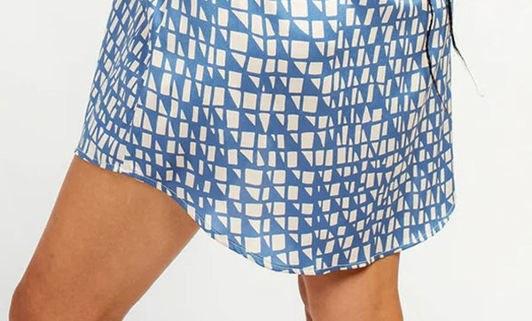 Close-up of Alder shirtdress hem in blue and white geometric print showing curved hemline detail