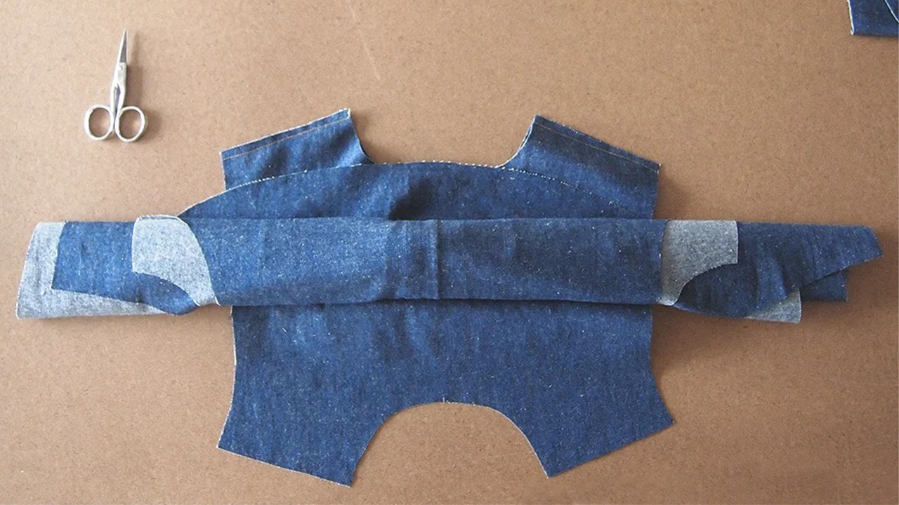 Alder dress front and back rolled inside yoke pieces like a burrito, shown flat with scissors, demonstrating burrito method