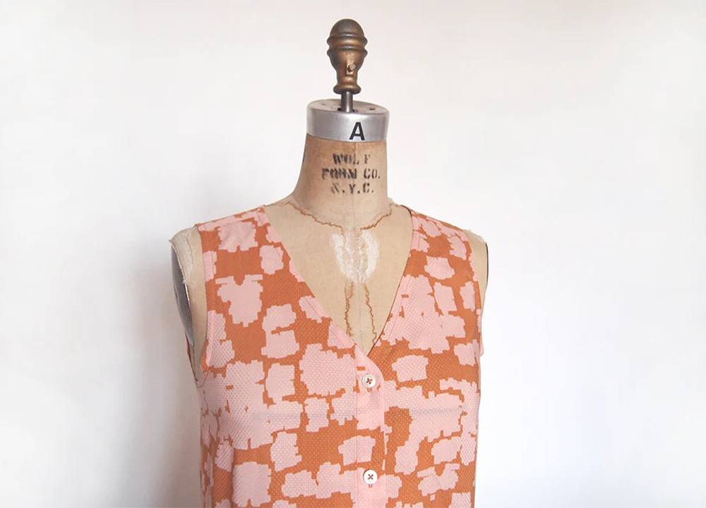 Alder v-neck variation on dress form in coral and pink abstract print showing collarless neckline with button front closure