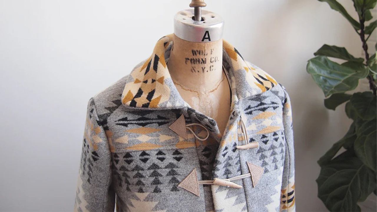 Completed Cascade Duffle Coat in geometric print wool on dress form showing collar, toggle closures, and patch pockets