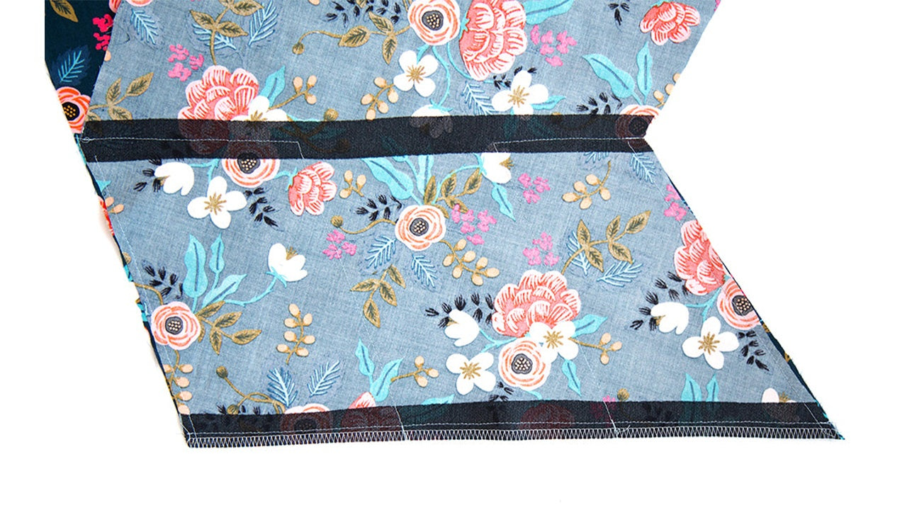 Blue floral Farrow Dress front showing completed inseam pocket construction with diagonal seam and pocket opening between bodice and skirt.