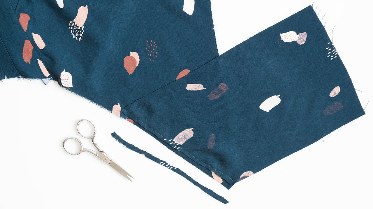 Felix Dress pocket pieces attached to bodice and skirt in teal abstract print fabric with scissors nearby