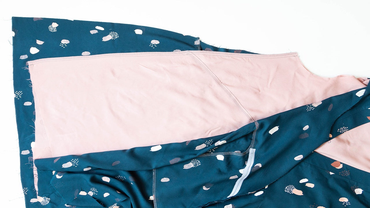 Felix Dress side seams sewn showing teal abstract print self fabric with pink lining and serged seam allowances
