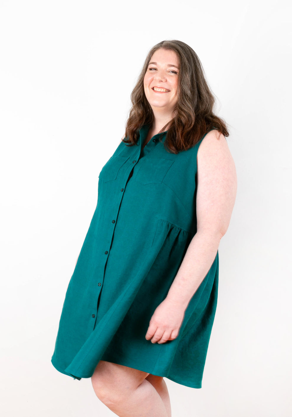 Model walking in Alder Shirtdress View B in teal linen, showing movement and flared silhouette.