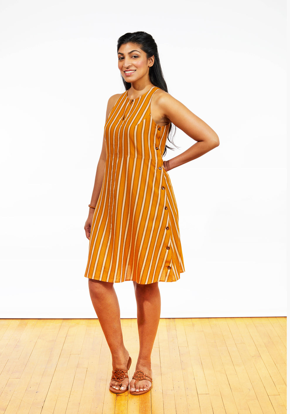 Three-quarter angle view of Austin Dress in orange stripe rayon, highlighting side button closure.