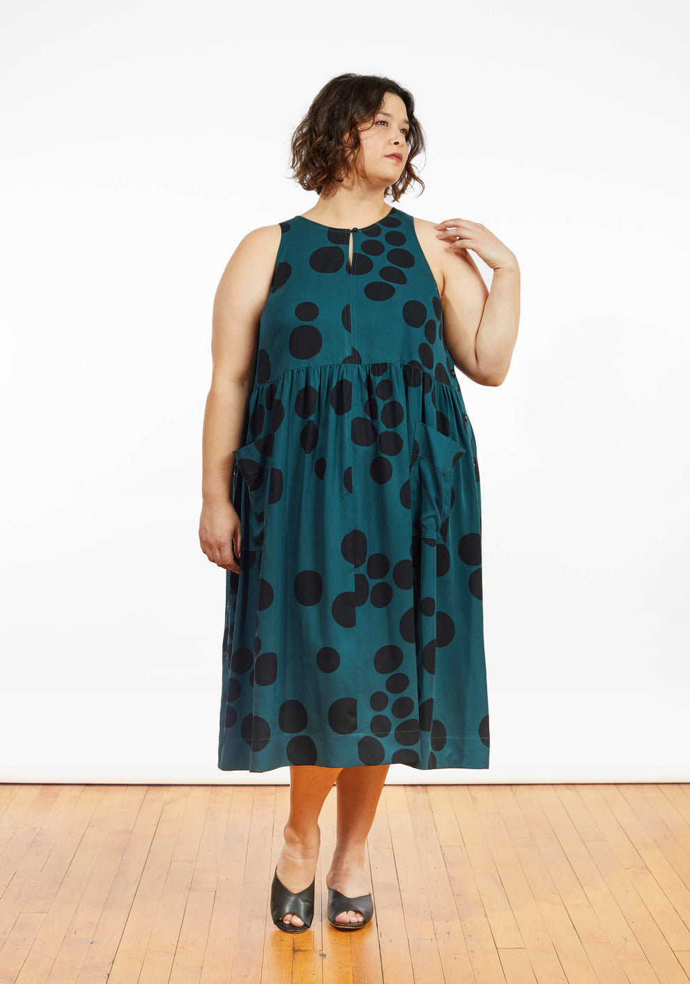 Model: Size 24, 5'5" | Front view of Austin Dress in teal dot print with gathered skirt and patch pockets, worn by model.