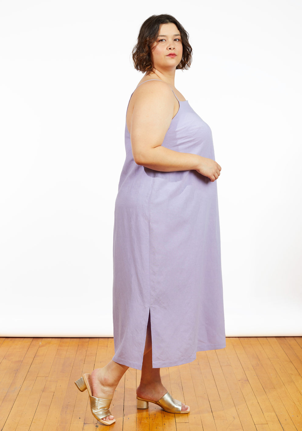 Side view of Myra Dress in lilac fabric, showing midi length with side slit and spaghetti straps.