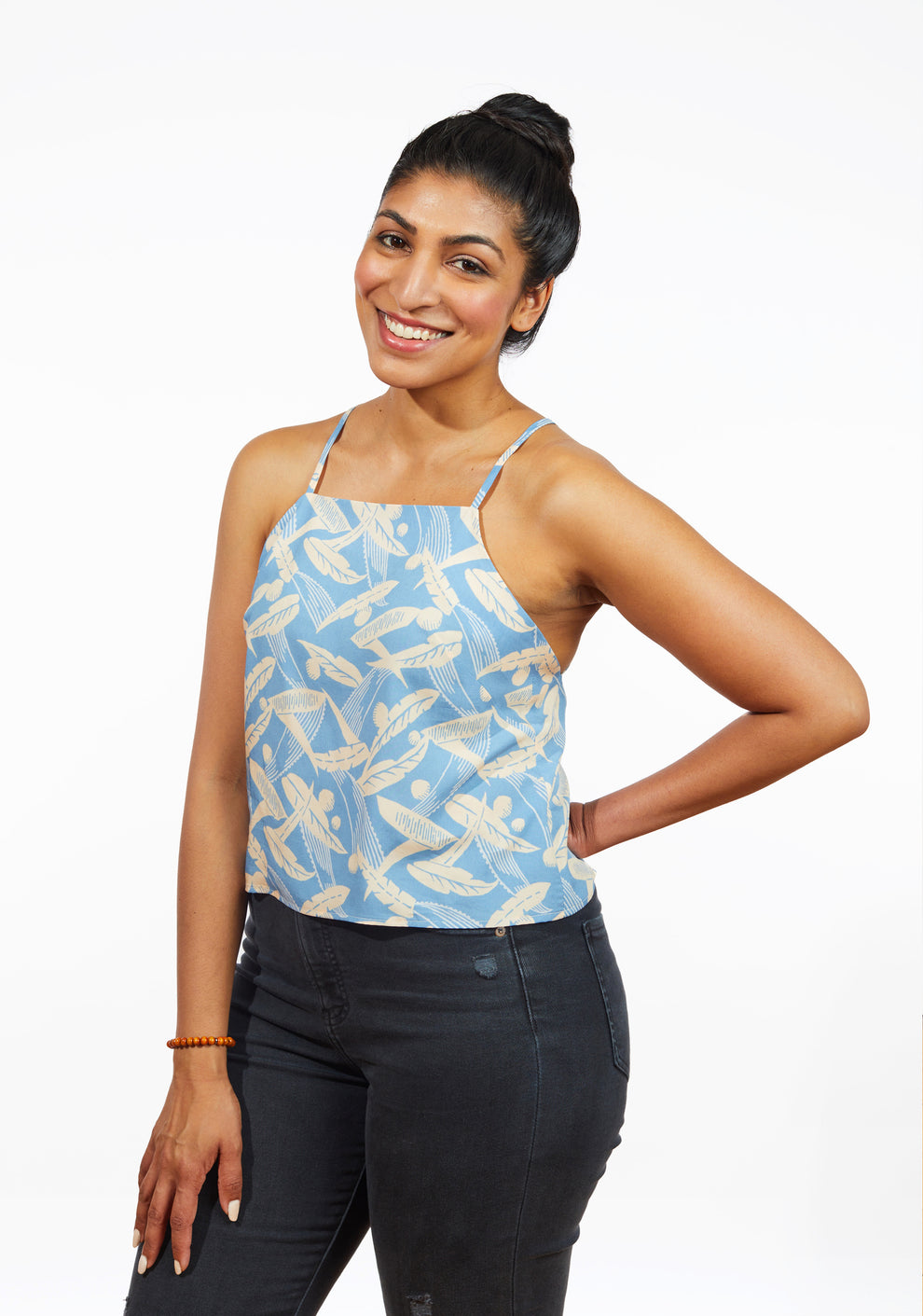 Smiling model wearing Myra Top in blue feather print with black jeans, sizes 0-18.