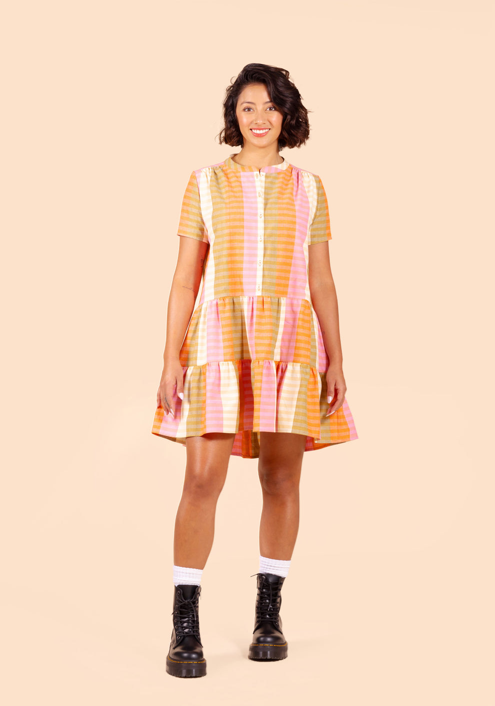Model: Size 2, 5'7" | Front view of the Poppy Dress in colorful striped fabric with short sleeves and tiered skirt.