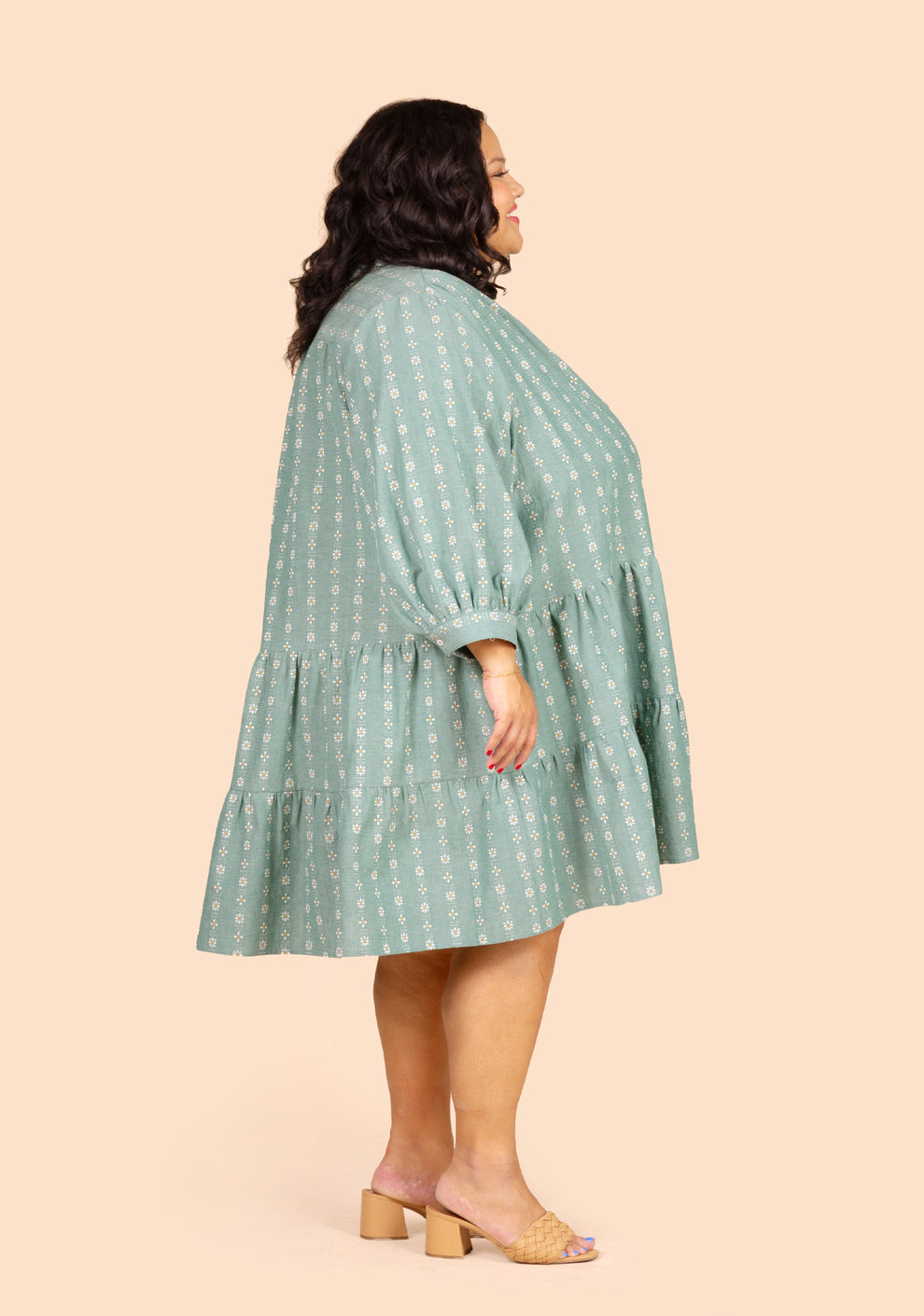 Side view of short Poppy Dress View C in green floral with full sleeves and gathered skirt.