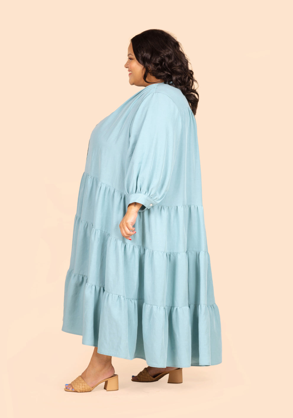 Side profile of long Poppy Dress View D in light blue, showing tiered skirt and long sleeves.