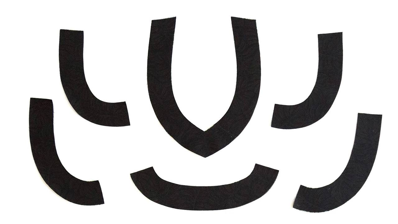 Black interfaced pieces laid flat showing curved neckline and armhole facing shapes for Hadley Top construction