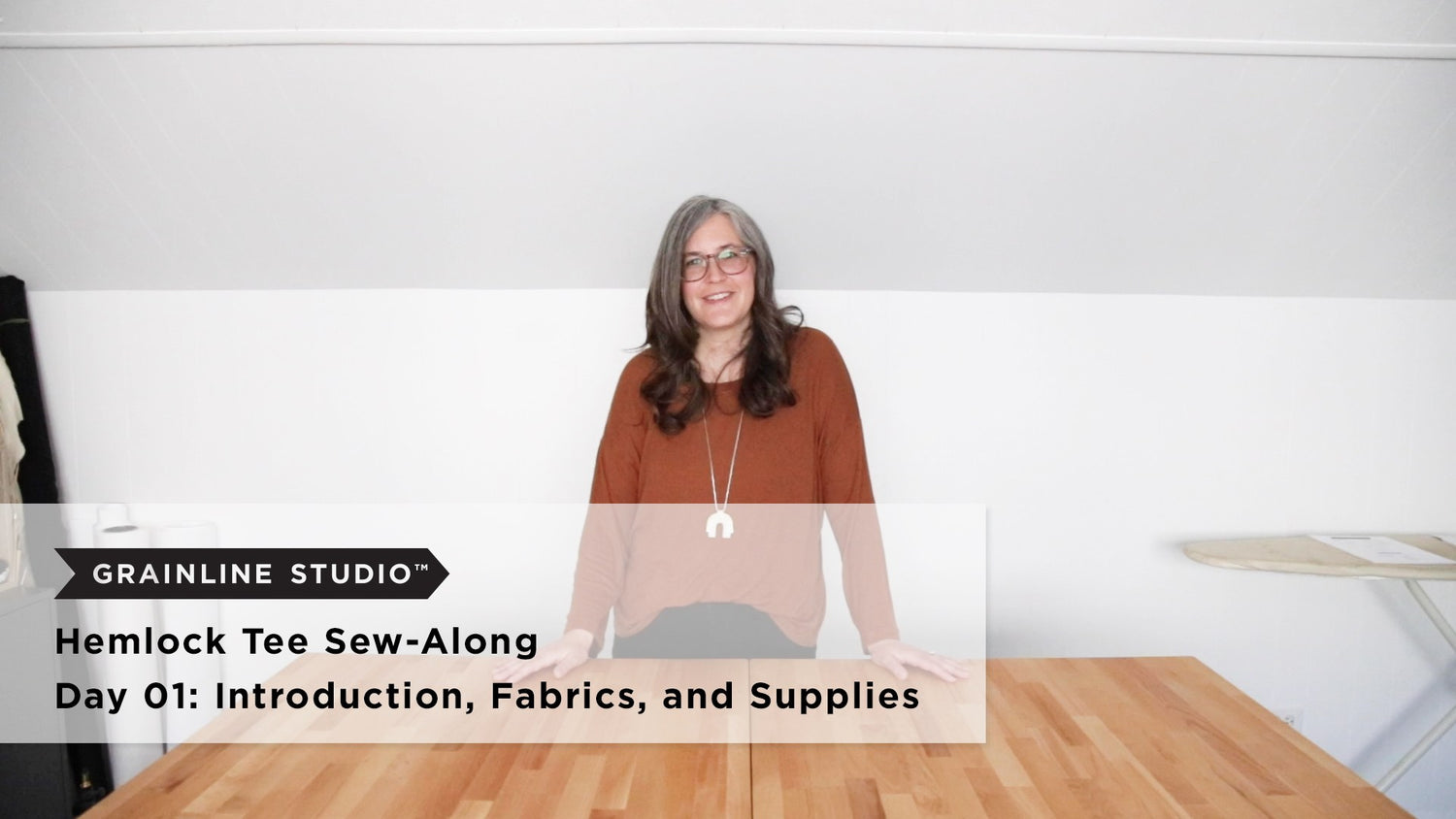 Hemlock Tee Sew-Along Day 01 video thumbnail, woman standing at wood work table in sewing studio