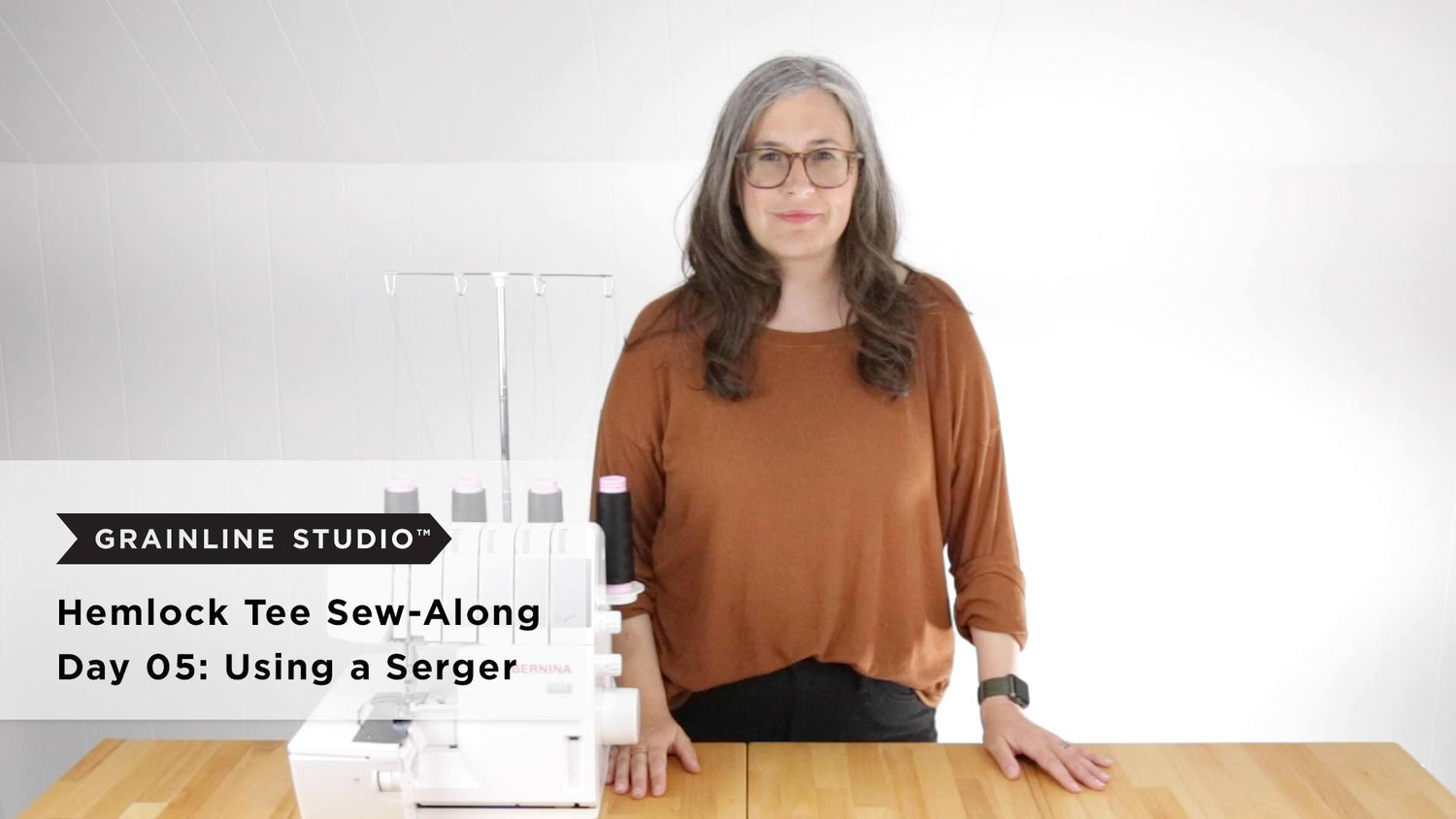 Hemlock Tee Sew-Along Day 05 thumbnail, woman standing beside Bernina serger with thread cones