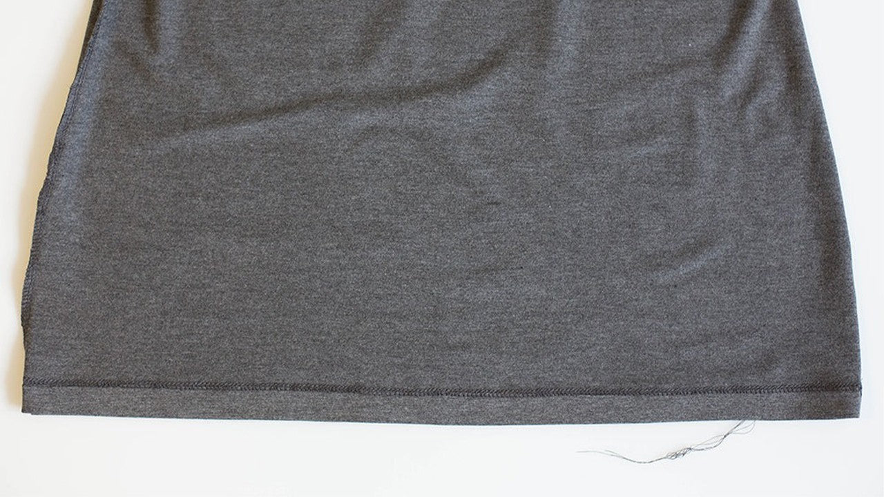 Gray Lark Tee hem showing coverstitch finish on wrong side with raw edge enclosed inside stitching line