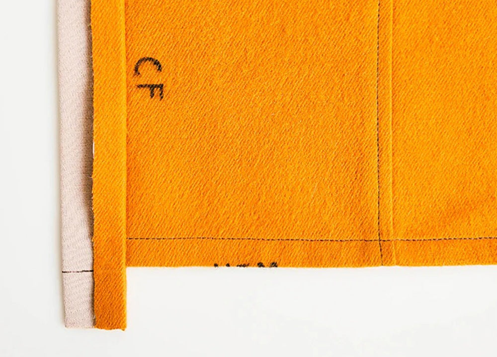 Orange twill fabric showing alternate button placket method with center front marking and folded edge construction