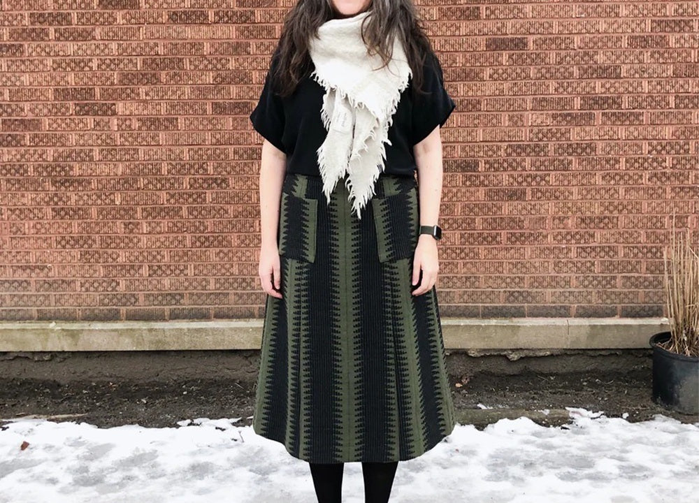 Woman wearing Reed Skirt View B in green jacquard print showing lengthened version without visible hem band seam in snow
