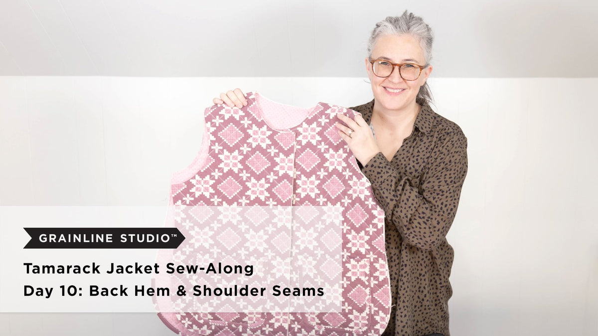 A quilted Tamarack jacket body in pink floral print held up showing the fully assembled front and back with completed shoulder seams