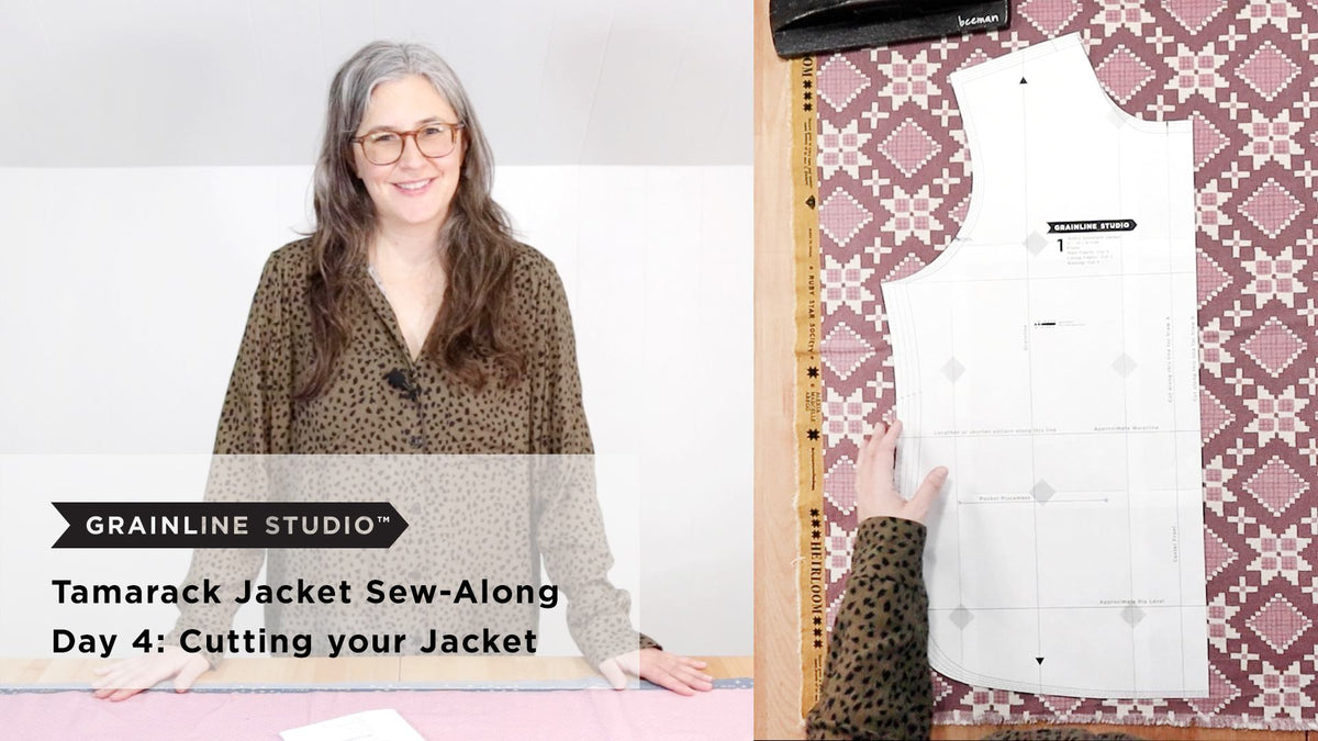 Jen leaning over a cutting table with a pink printed fabric and a large Tamarack pattern piece laid out, with a quilting ruler along the selvage
