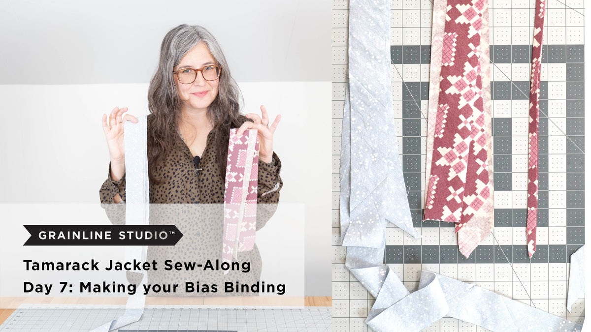 Two strips of bias binding held up, one in a light gray print and one in a pink floral print, beside a cutting mat showing fabric cut on the diagonal