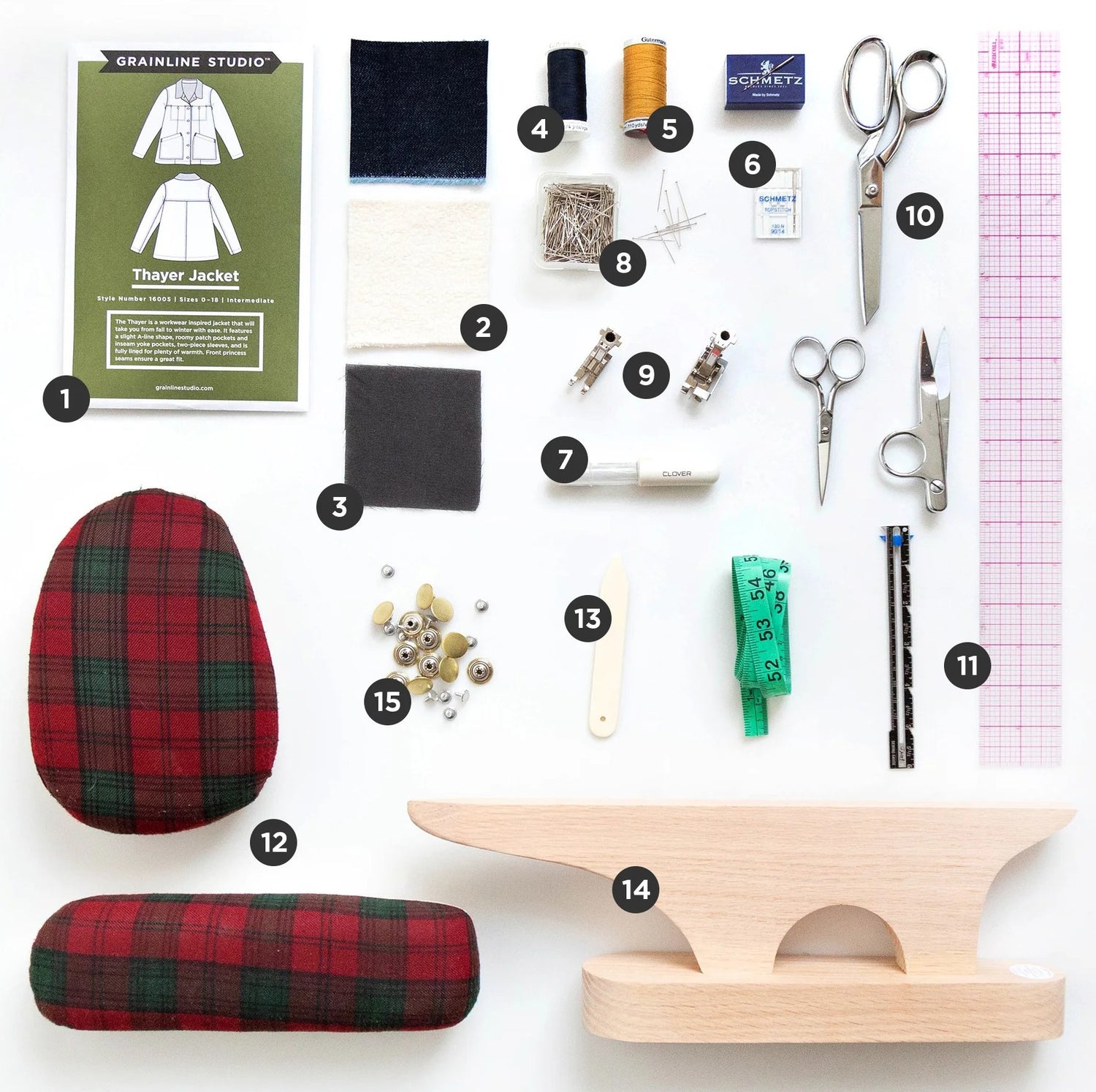 Flat lay of Thayer Jacket sewing supplies including pattern, fabrics, thread, needles, scissors, rulers, and snap closures