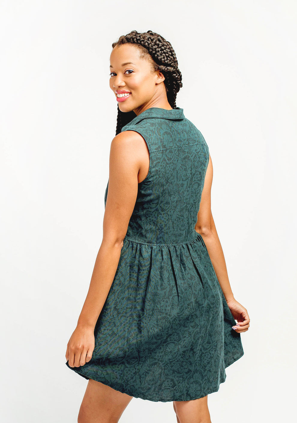 Side view of sleeveless green Alder Shirtdress with fitted bodice and gathered skirt.