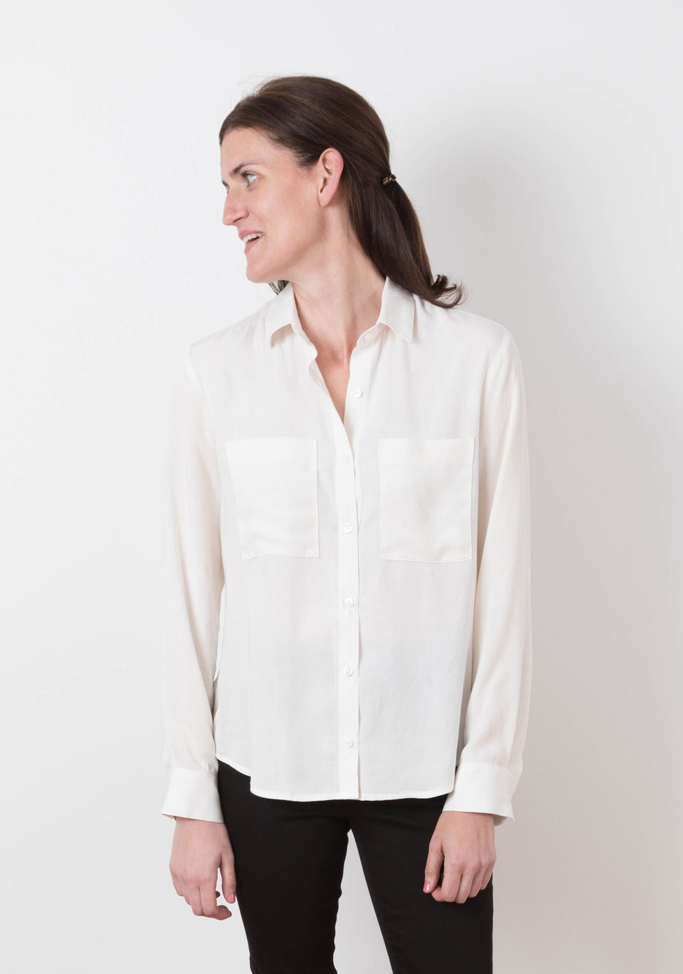 Side view of Archer View B shirt in white fabric, showing relaxed fit, button band, and gathered back hem.