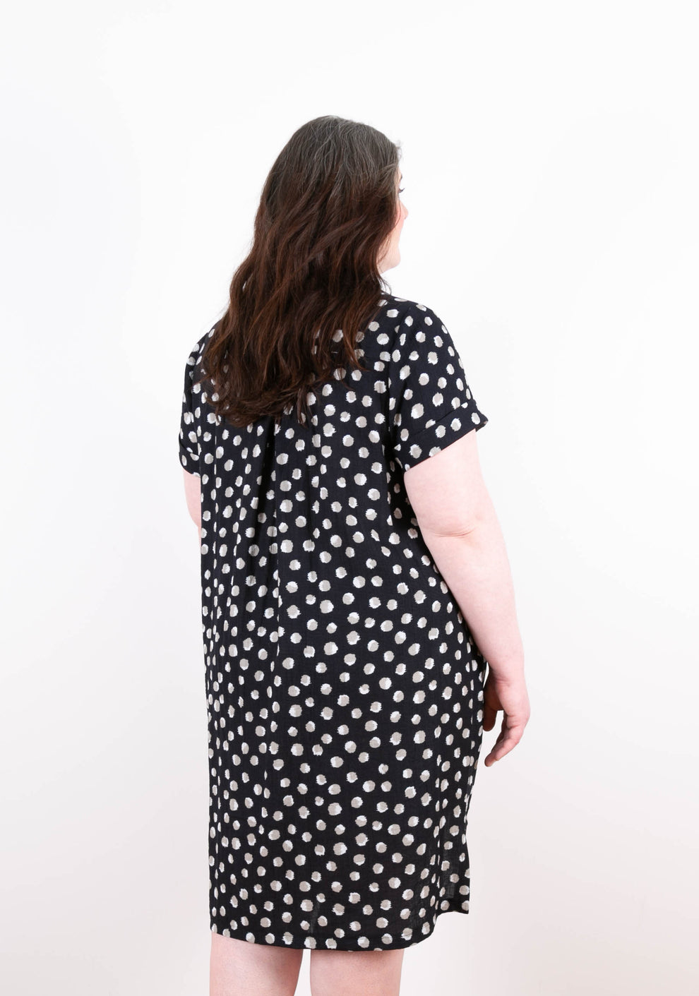 Three-quarter back view of Augusta Dress in dot print, highlighting pleat and soft volume.